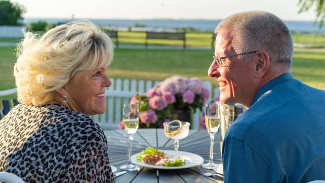 Ruth og Lars kigger hinanden dybt i øjnene på Bandholm Hotels terrasse